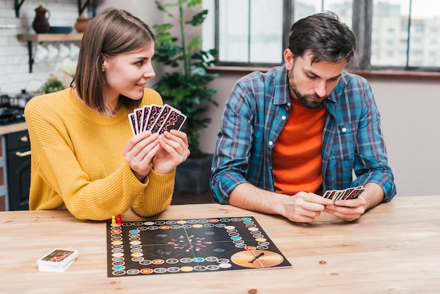 Pareja joven jugando el tablero de juego en el escritorio de madera