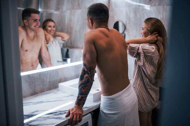 Pareja joven junto en el baño a la hora de la mañana.