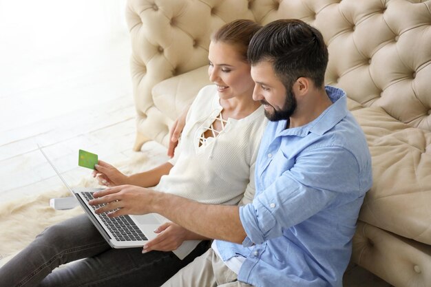 Pareja joven con laptop en casa Concepto de compras por Internet