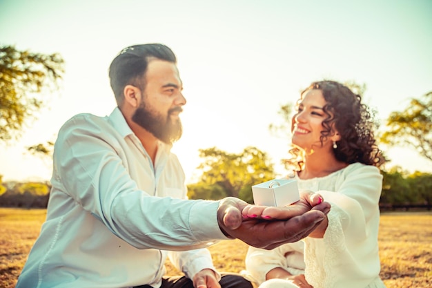 pareja joven, manos de valor en cartera, en, un, parque, en, ocaso