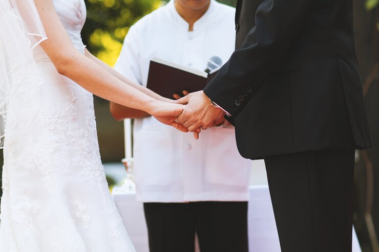 Pareja joven mantenga la mano en la ceremonia de boda