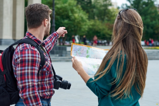 Foto pareja joven con un mapa de la ciudad. turistas felices visitando la ciudad con mapa