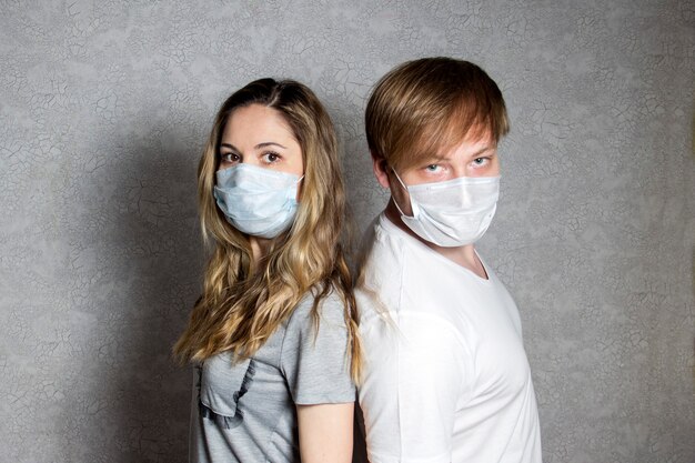 Una pareja joven con una mascarilla durante un brote del virus.