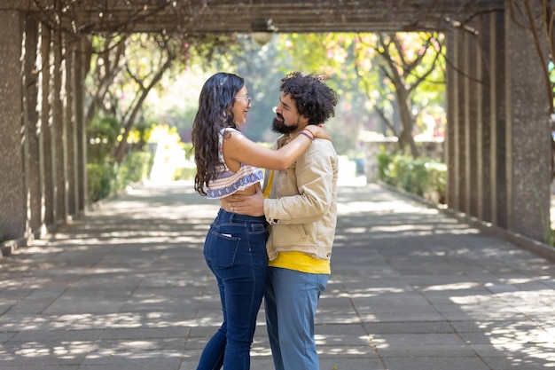 Pareja joven mexicana abrazándose afuera en el día de san valentín