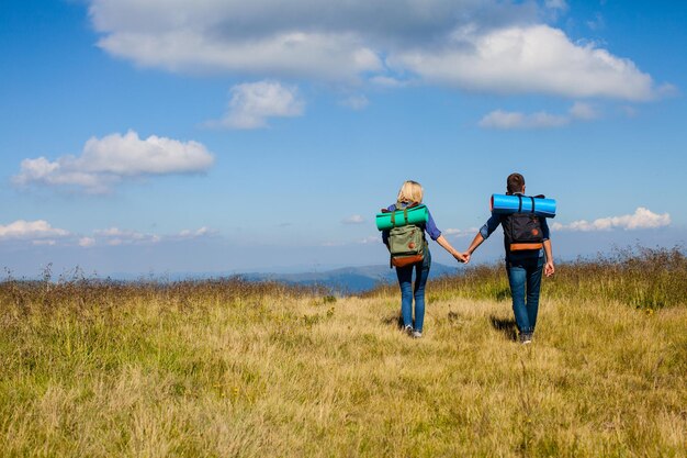 Pareja joven mientras caminaba viajando en las montañas