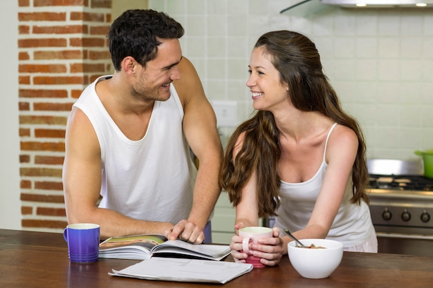 Pareja joven mirando el uno al otro mientras está de pie cerca de encimera de cocina