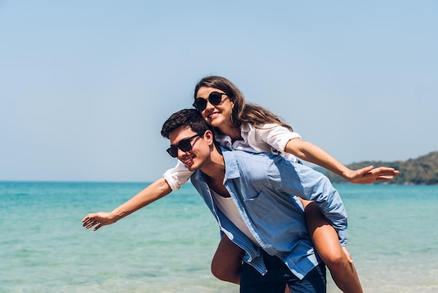 Foto una pareja joven mirando el mar contra el cielo