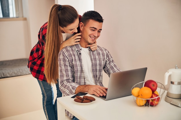 Pareja joven mirando la pantalla del portátil