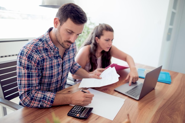 Pareja joven mirando papeles de finanzas familiares