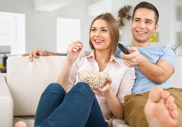 Pareja joven, mirar televisión, en casa