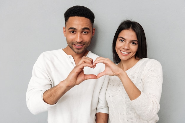 Pareja joven mostrando corazón con manos