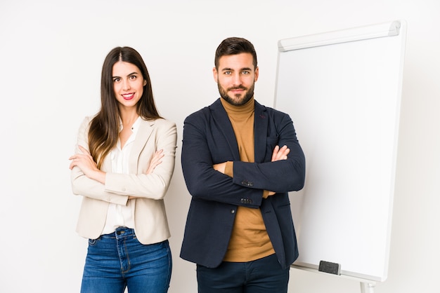 Pareja joven de negocios caucásico que se siente seguro, cruzando los brazos con determinación.