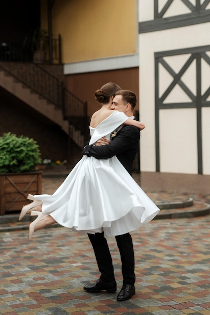 Pareja joven novia y novio en un vestido corto blanco