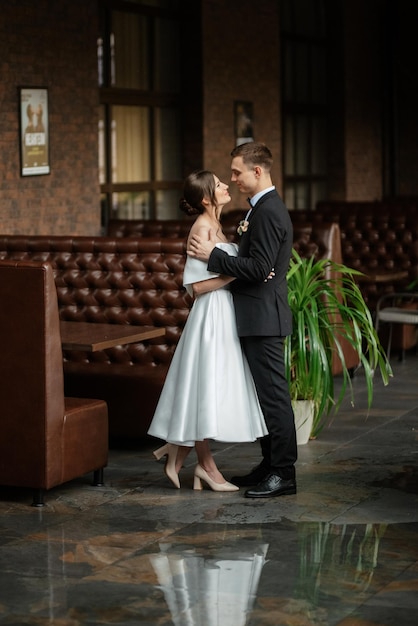 Pareja joven novia y novio en un vestido corto blanco