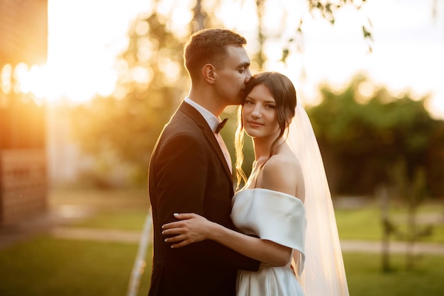 Pareja joven el novio con un traje negro y la novia con un vestido corto blanco