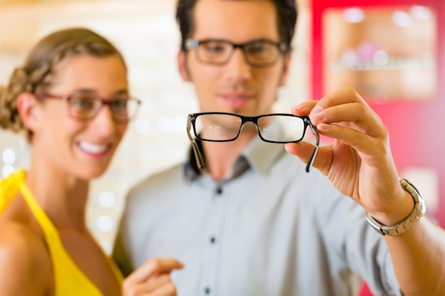 Foto pareja joven en óptica con gafas