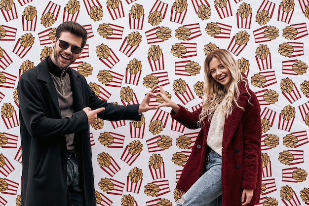 Pareja joven en la pared de fondo de la pared de la marca de la calle diseñada con comida de la calle