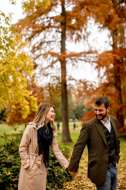 Pareja joven en el parque de otoño