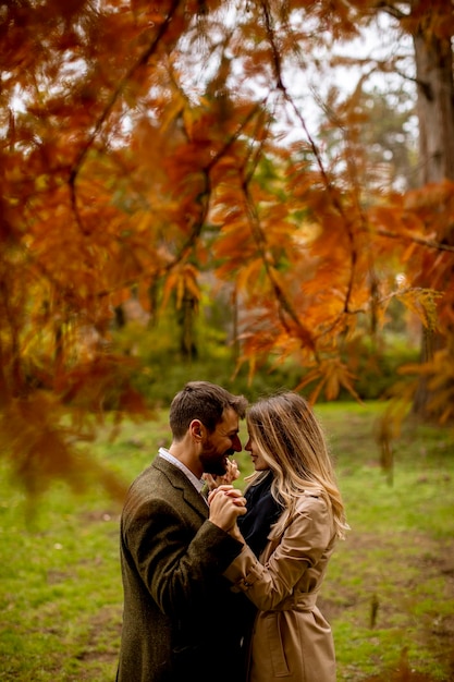 Pareja joven en el parque de otoño