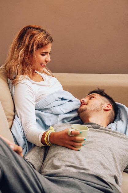 Foto pareja joven pasando el tiempo de ocio en el sofá en casa