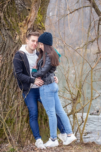 Pareja joven pasar tiempo juntos en el lago Gebart en un brumoso día de invierno en Zalaegerszeg, Hungría