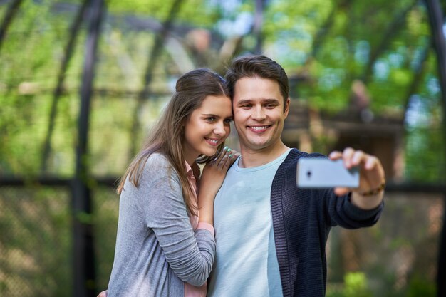 pareja joven paseando por el parque y tomando fotografías