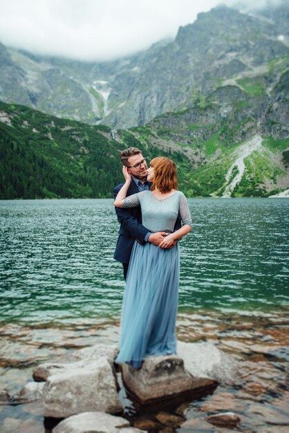 Pareja joven en un paseo cerca del lago rodeado por las montañas de los Cárpatos