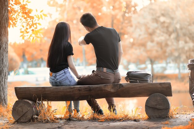 Pareja joven en un paseo en otoño hermoso parque al atardecer