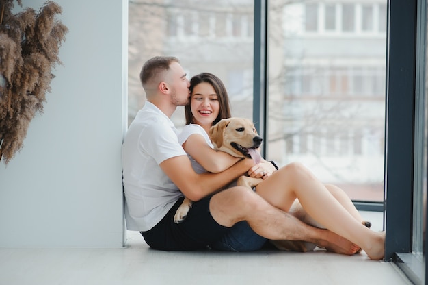 Pareja joven con un perro en casa