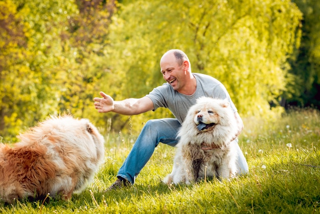 Pareja joven con los perros en el parque