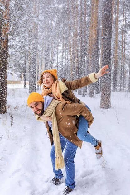 Una pareja joven de pie bajo un árbol cubierto de nieve