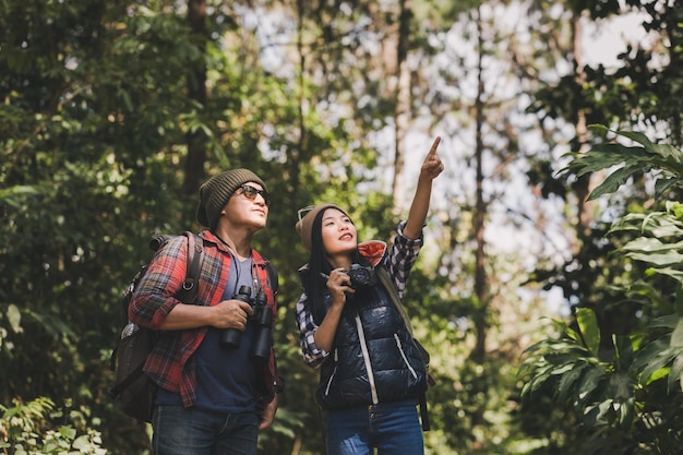 Foto una pareja joven de pie en el bosque.