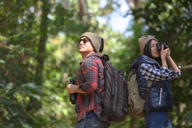 Foto una pareja joven de pie contra los árboles