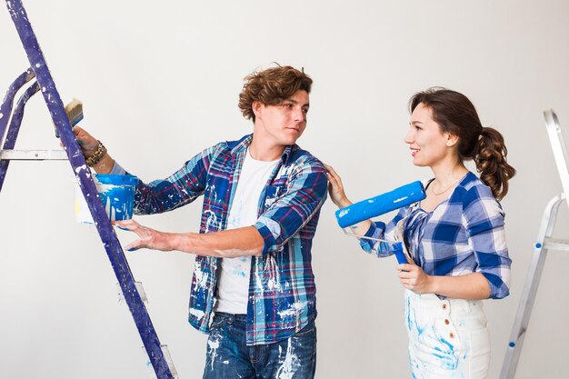 Foto una pareja joven de pie contra la pared