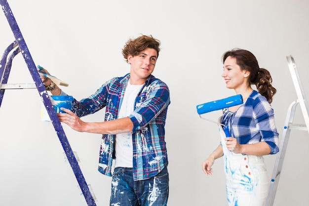 Foto una pareja joven de pie contra la pared