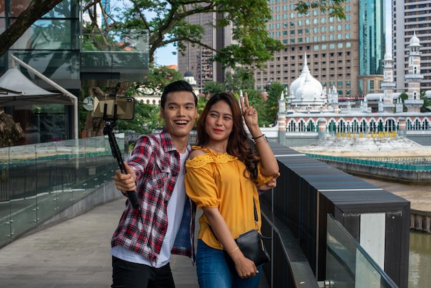 Foto una pareja joven de pie frente a un canal en una ciudad