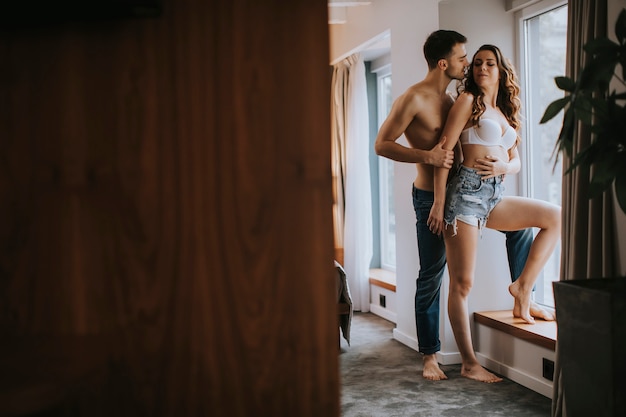 Pareja joven de pie en la habitación