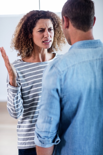 Foto pareja joven de pie juntos y discutiendo después de una pelea