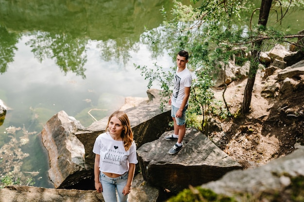 Pareja joven en piedra cerca del lago