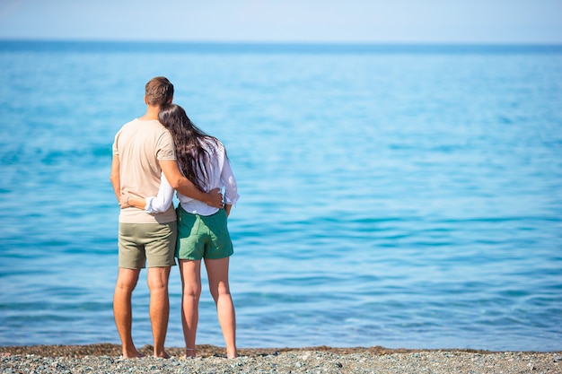 Pareja joven en la playa blanca durante las vacaciones de verano.