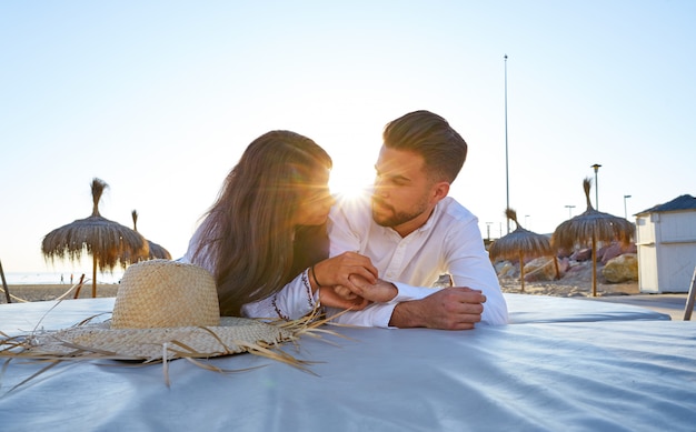 Pareja joven en la playa salón puesta de sol