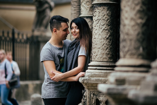 Pareja joven posando en columnas de la ciudad