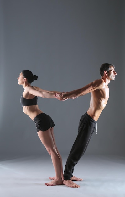 pareja joven, practicar, acro, yoga, en, estera, en, estudio, juntos, acroyoga, pareja, yoga, pareja, yoga