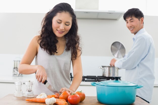 Pareja joven preparando comida juntos en la cocina