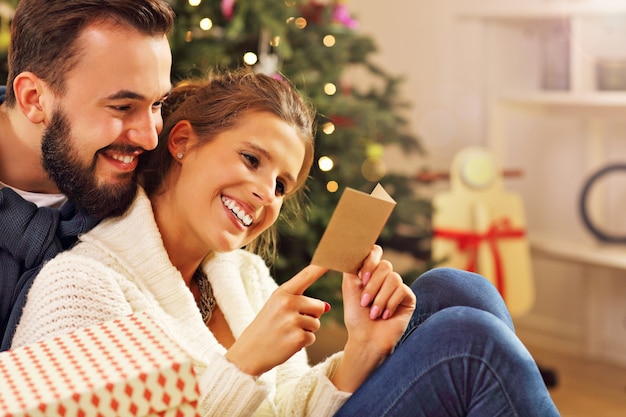 pareja joven, con, presente, encima, árbol de navidad