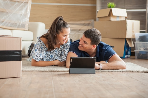 Pareja joven que se divierte en su nueva casa. Pareja hablando de nuevos comienzos