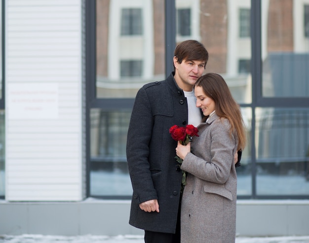 Pareja joven ramo de rosas en la ciudad. Día de San Valentín