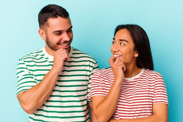 Pareja joven de raza mixta aislado sobre fondo azul.