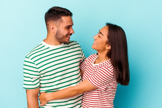 Foto pareja joven de raza mixta aislado sobre fondo azul.