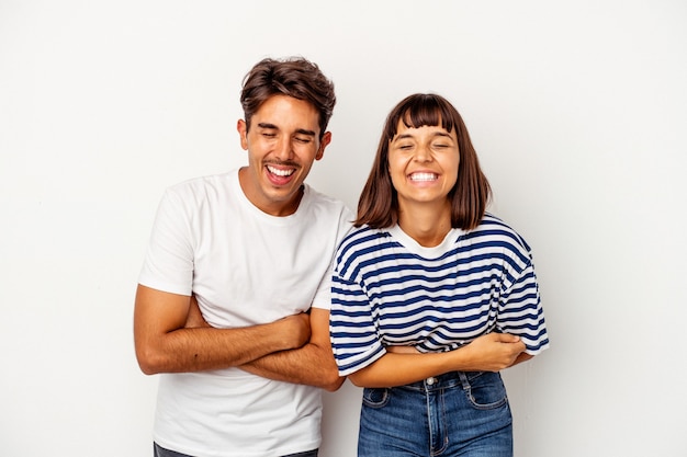 Pareja joven de raza mixta aislado sobre fondo blanco riendo y divirtiéndose.